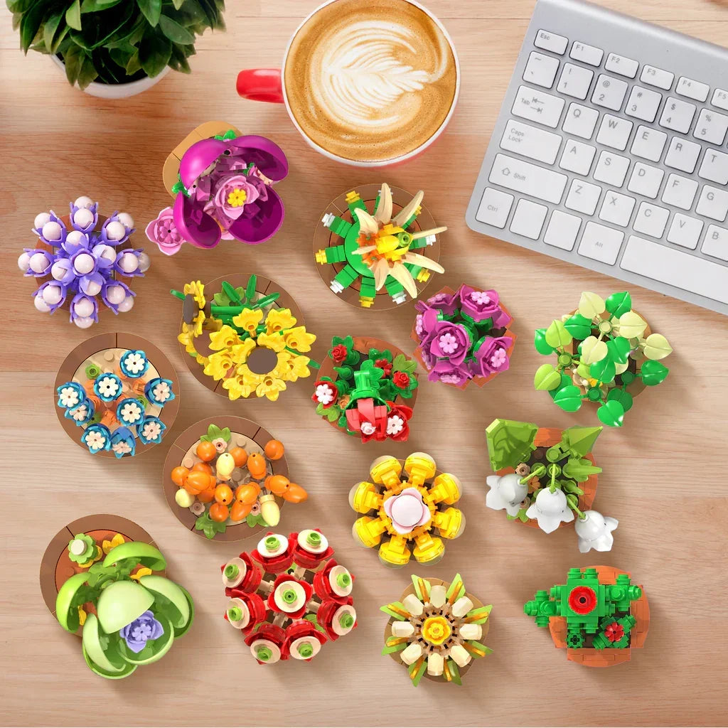 Verschiedene bunte Lego-Blumenarrangements auf einem Holztisch mit einer Tasse Kaffee und einer Tastatur