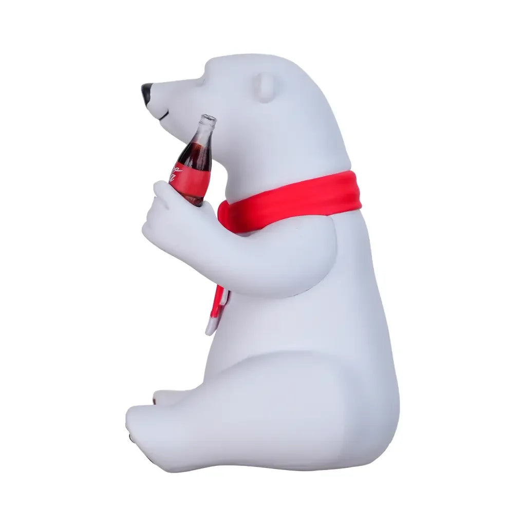 Sitzender Eisbär mit rotem Schal und Coca-Cola Flasche