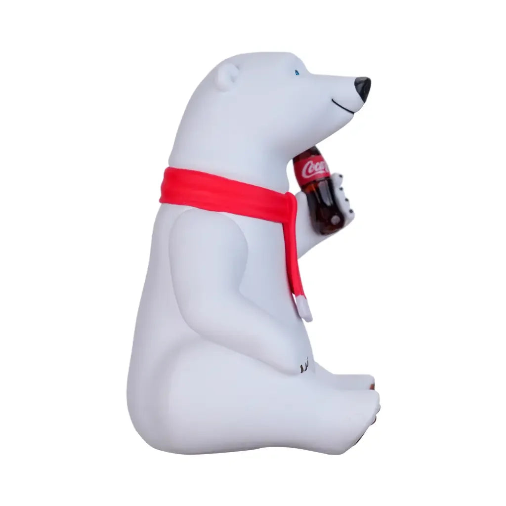 Sitzender Coca-Cola Eisbär mit rotem Schal und einer Coca-Cola Flasche