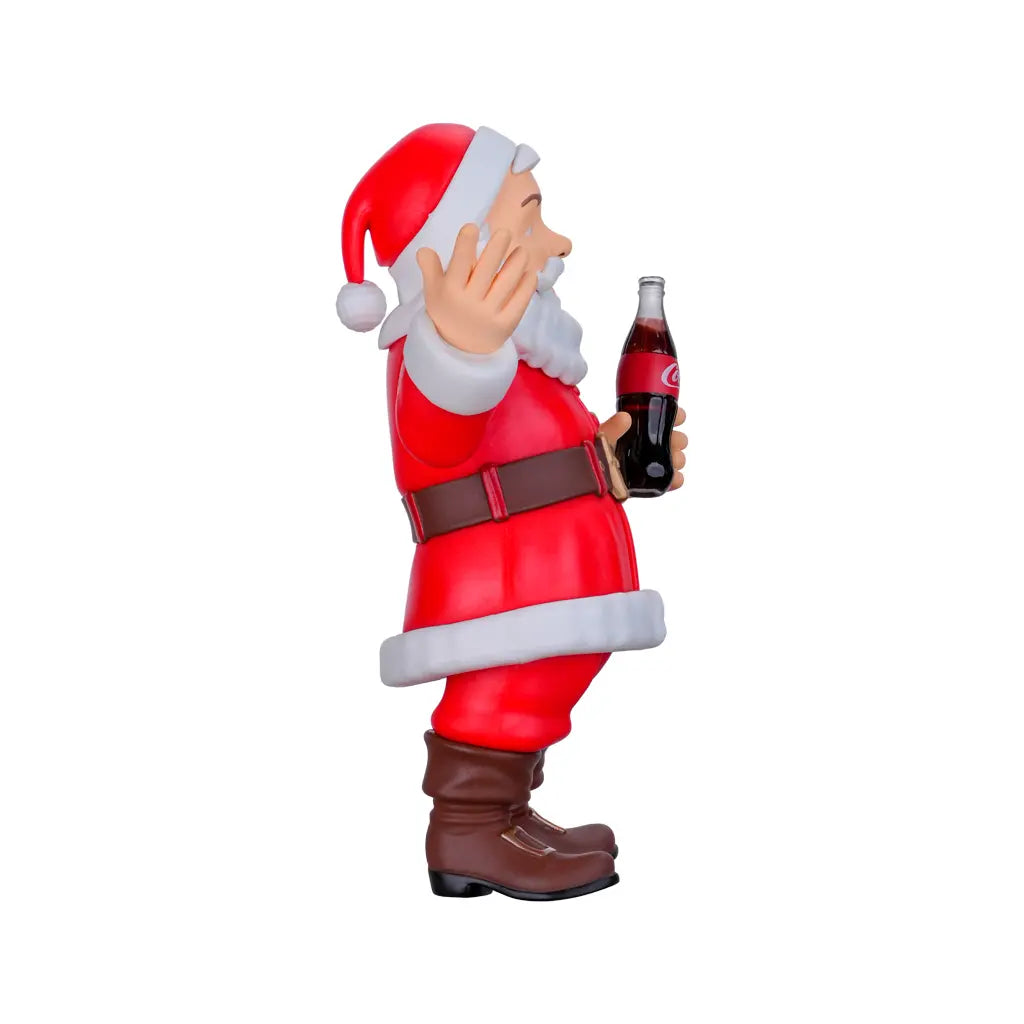 Weihnachtsmannfigur mit rotem Anzug, weißem Bart und Mütze, hält eine Coca-Cola Flasche
