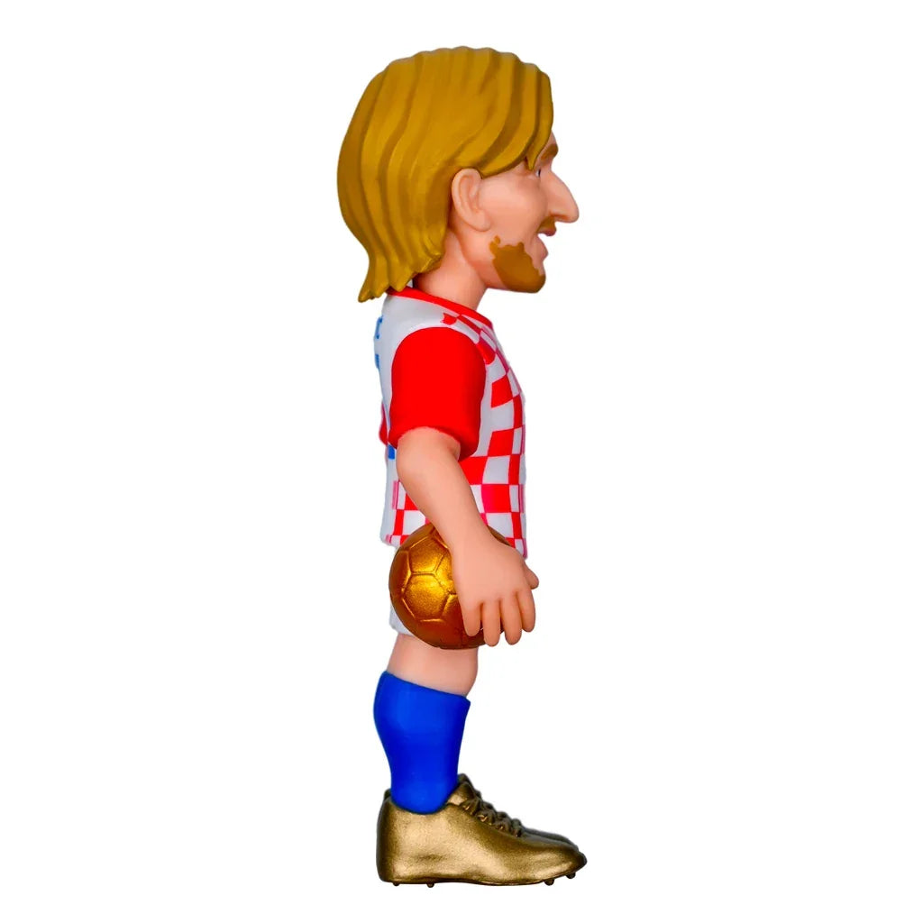 Karikatur eines Fußballspielers mit blonden Haaren, Bart, rot-weiß kariertem Trikot, blauen Socken und goldenen Schuhen