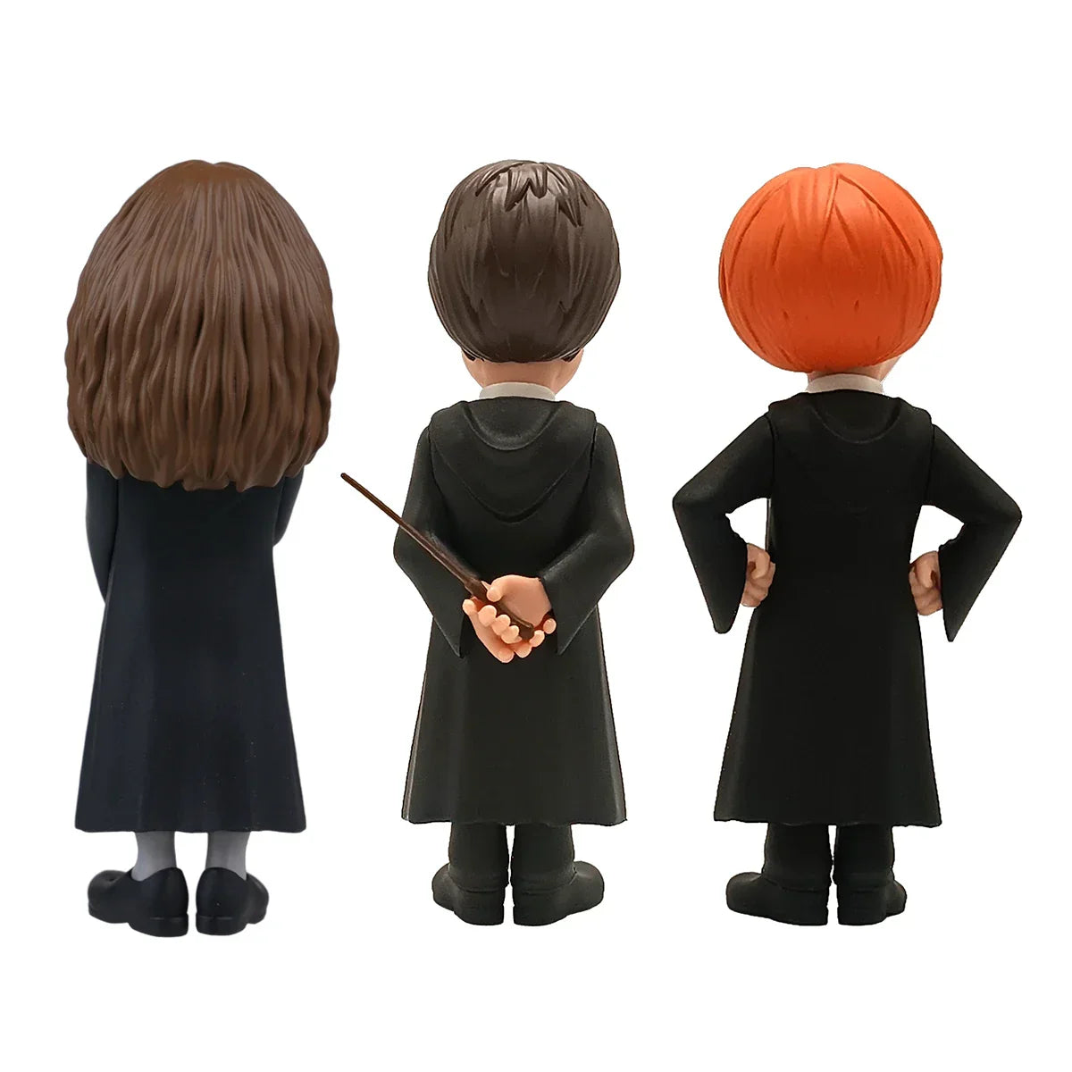 Rückansicht von drei Harry Potter Figuren in schwarzen Roben, eine hält einen Zauberstab