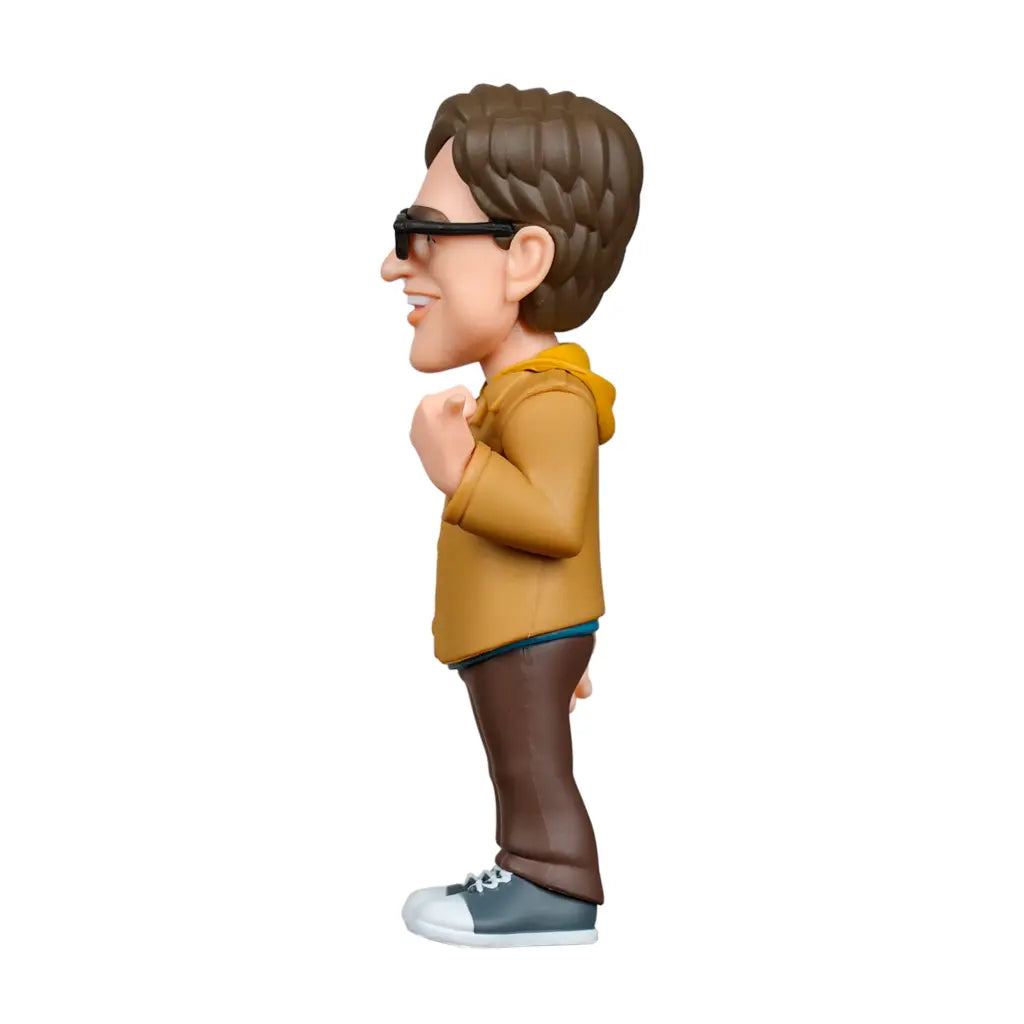 Seitenansicht einer Figur mit braunem Haar, Brille, gelbem Hoodie, brauner Hose und Turnschuhen