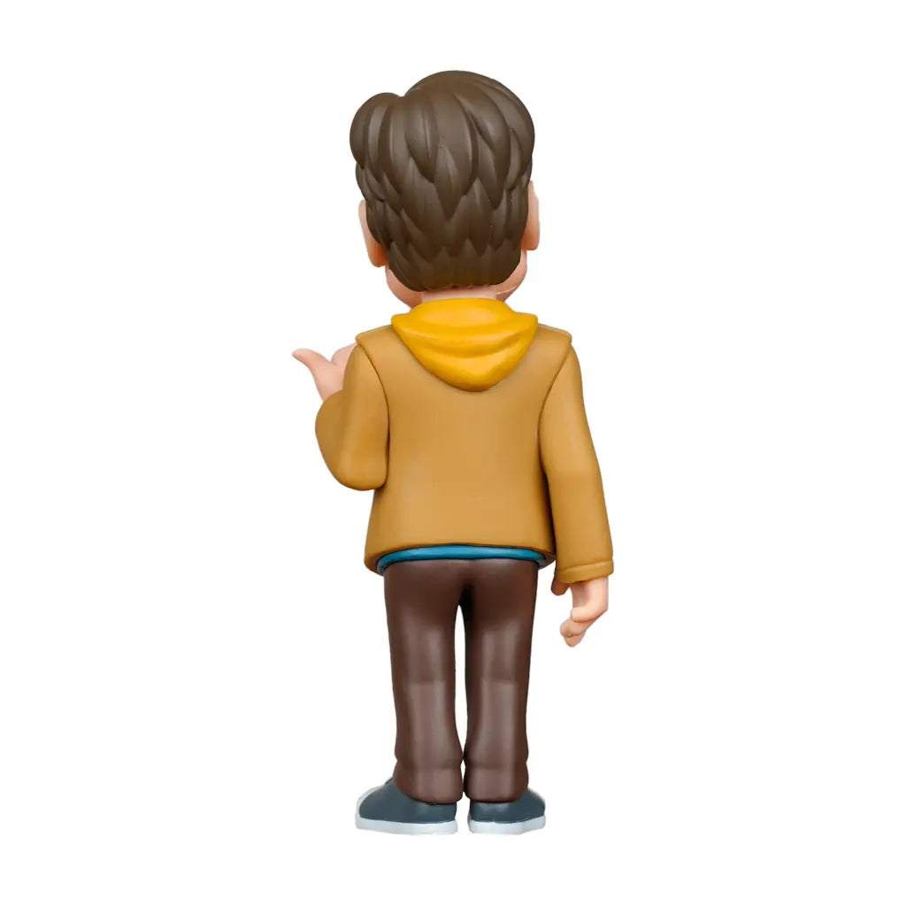 Rückansicht einer Figur mit braunem Haar, gelbem Kapuzenpullover und brauner Jacke