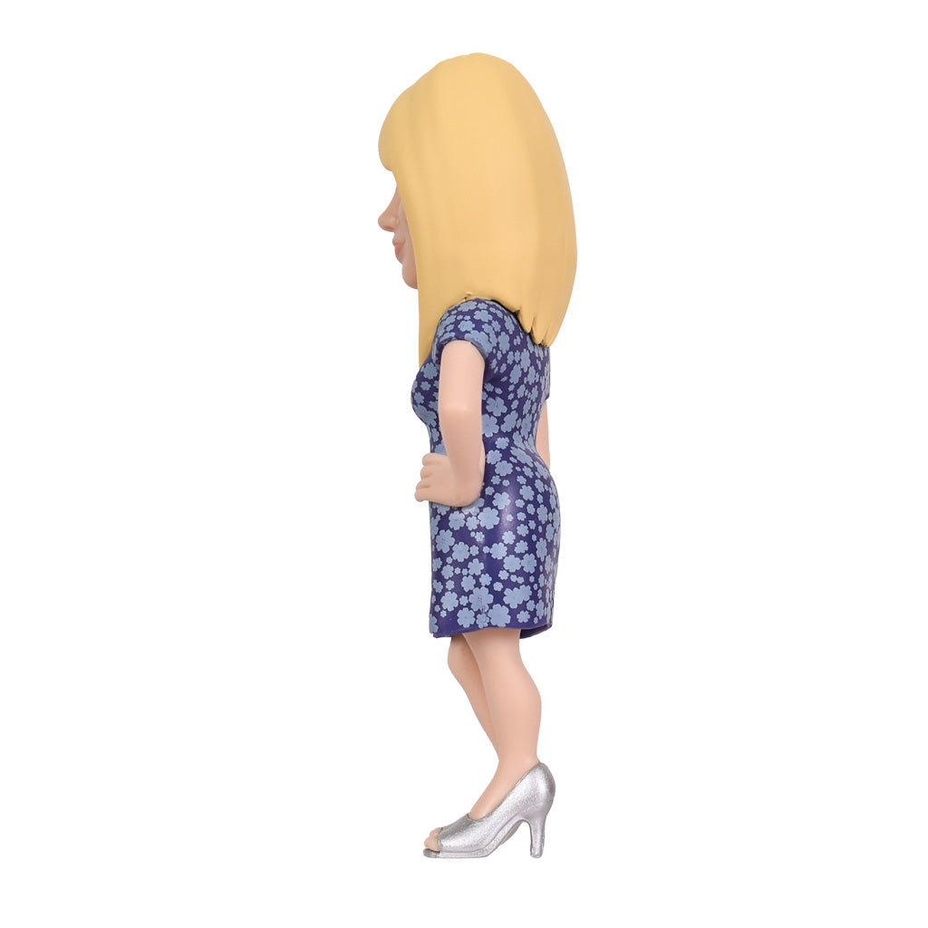 Figur einer blonden Frau in einem blauen Kleid mit Blumenmuster und silbernen High Heels von der Seite