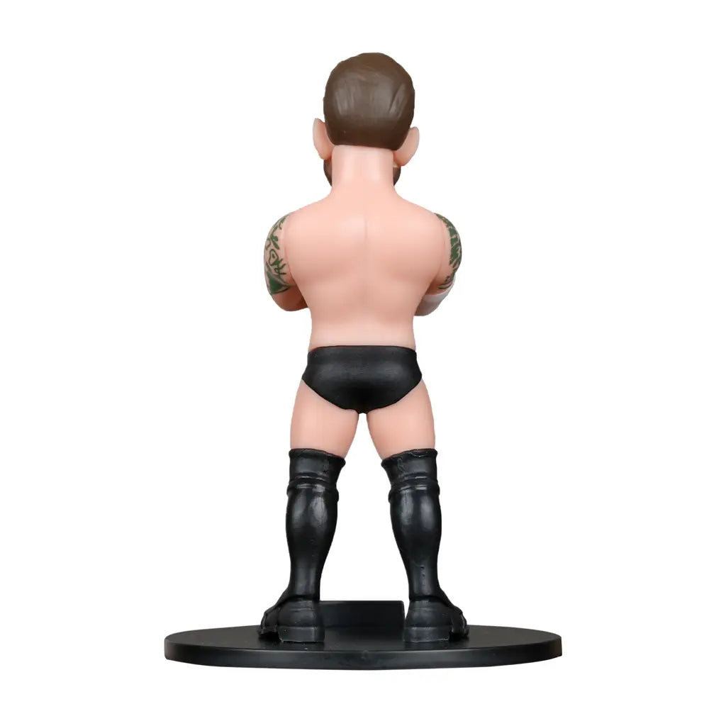 Rückansicht der CM Punk-Figur mit schwarzen Stiefeln und Shorts, Arme verschränkt, Tattoos auf den Armen