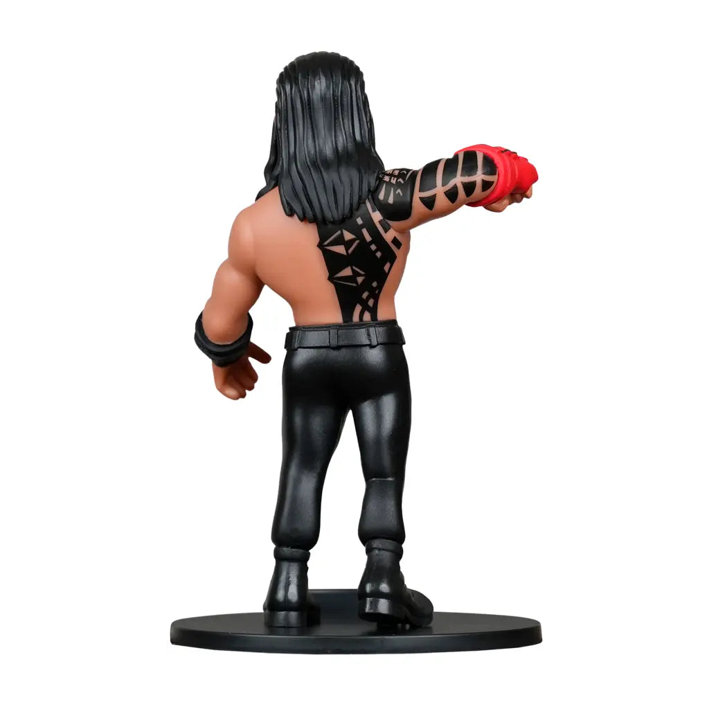 Rückenansicht einer Roman Reigns Figur mit langen schwarzen Haaren, schwarzen Hosen und Tattoos auf Rücken und Arm
