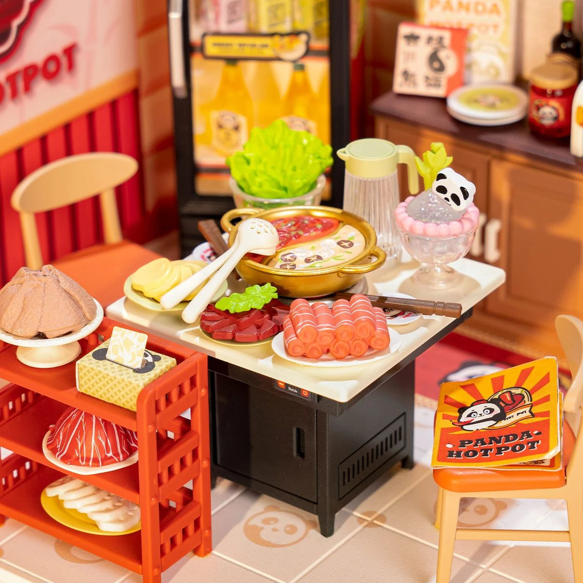 Miniatur-Hotpot-Set mit verschiedenen Zutaten, einem Topf und einem Panda-Dessert