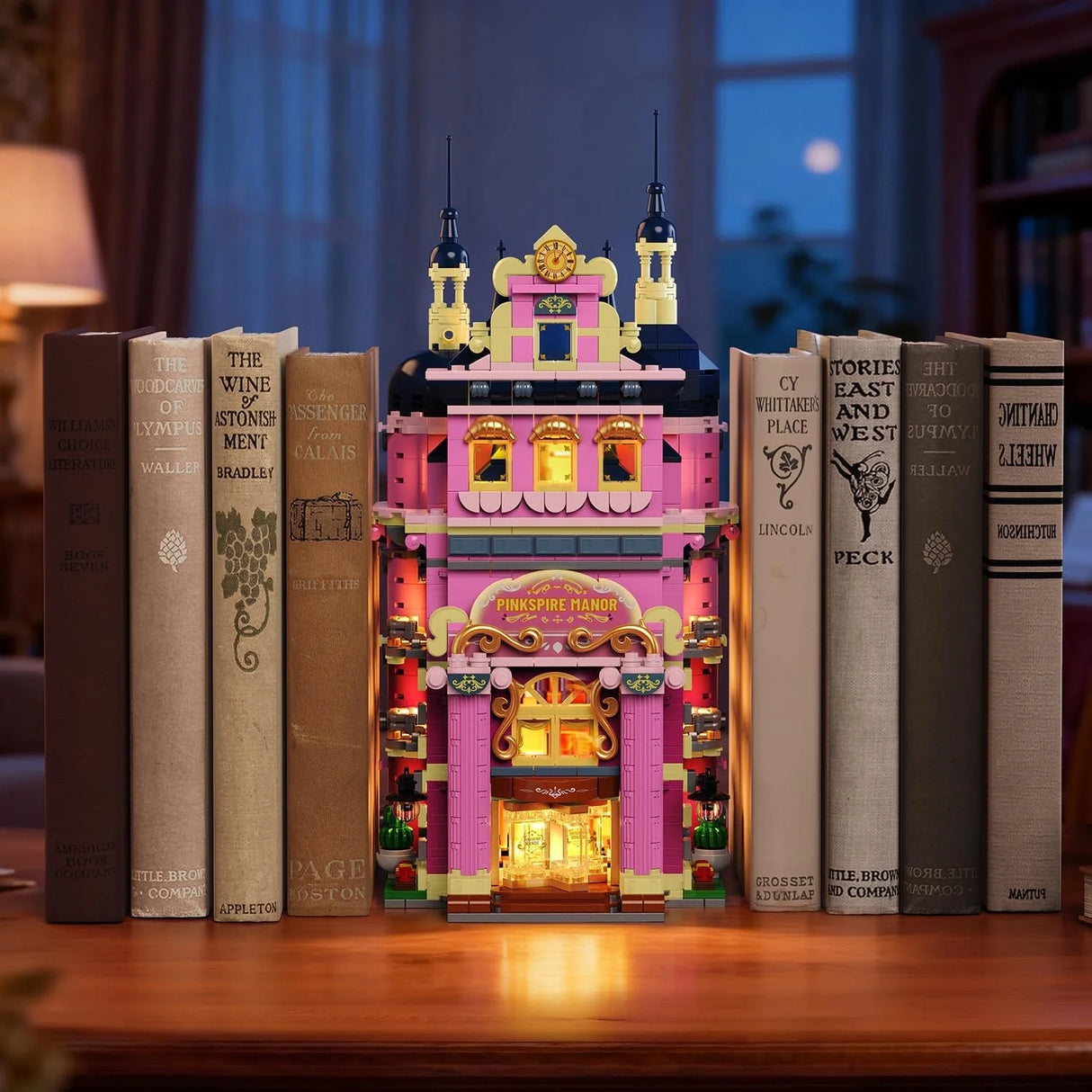 Ein rosafarbenes Spielzeughaus mit Lichtern, umgeben von Büchern auf einem Holztisch