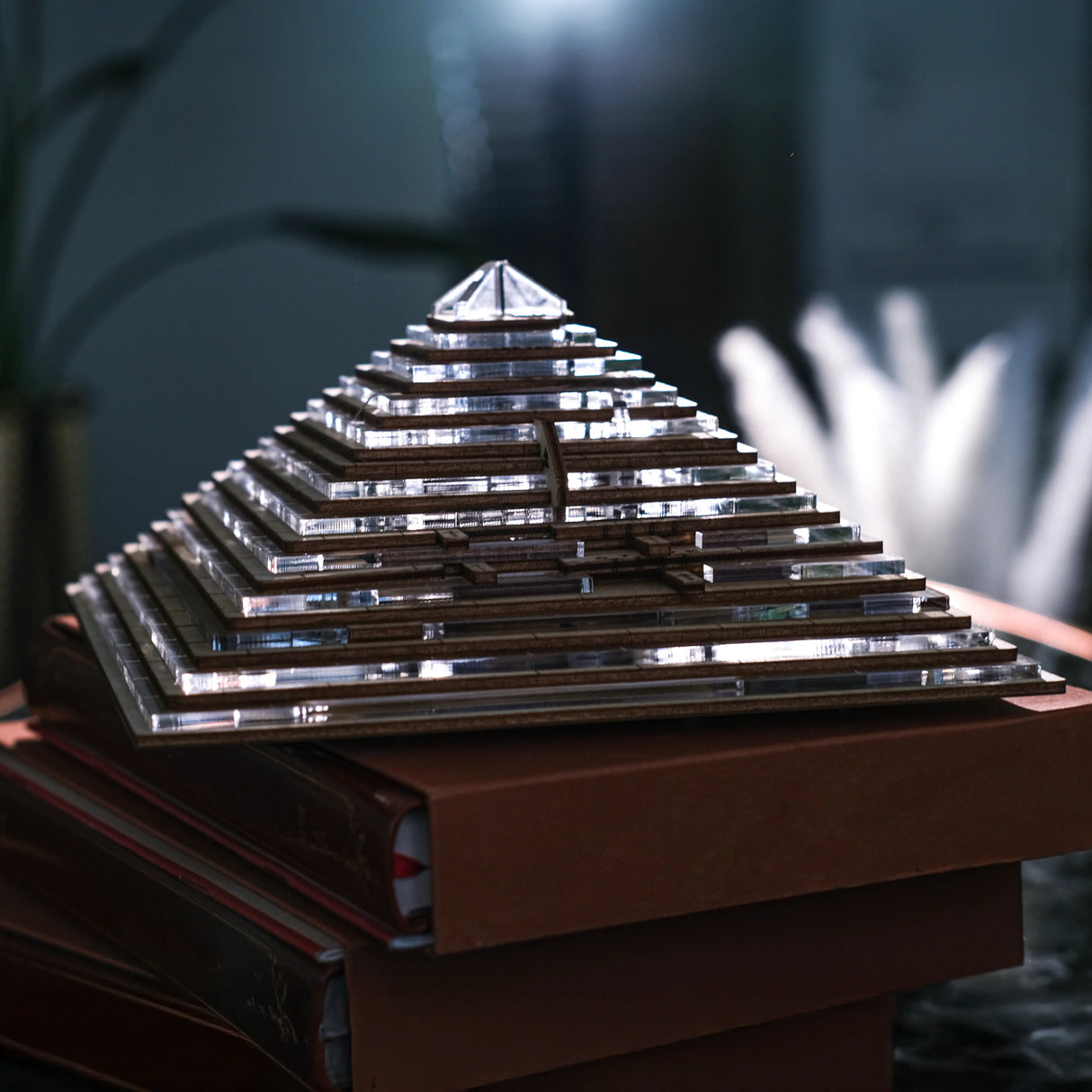 Eine Pyramide aus Holz und Glas auf einem Stapel brauner Bücher