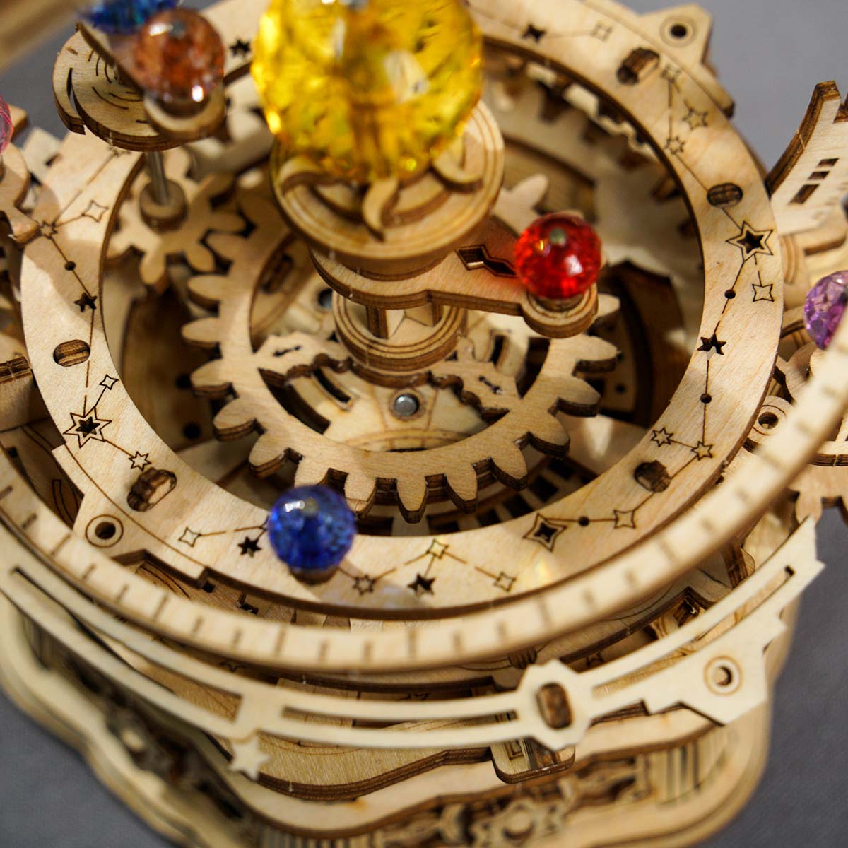 Mechanisches Modell eines Sonnensystems aus Holz mit farbigen Glaskugeln und Zahnrädern