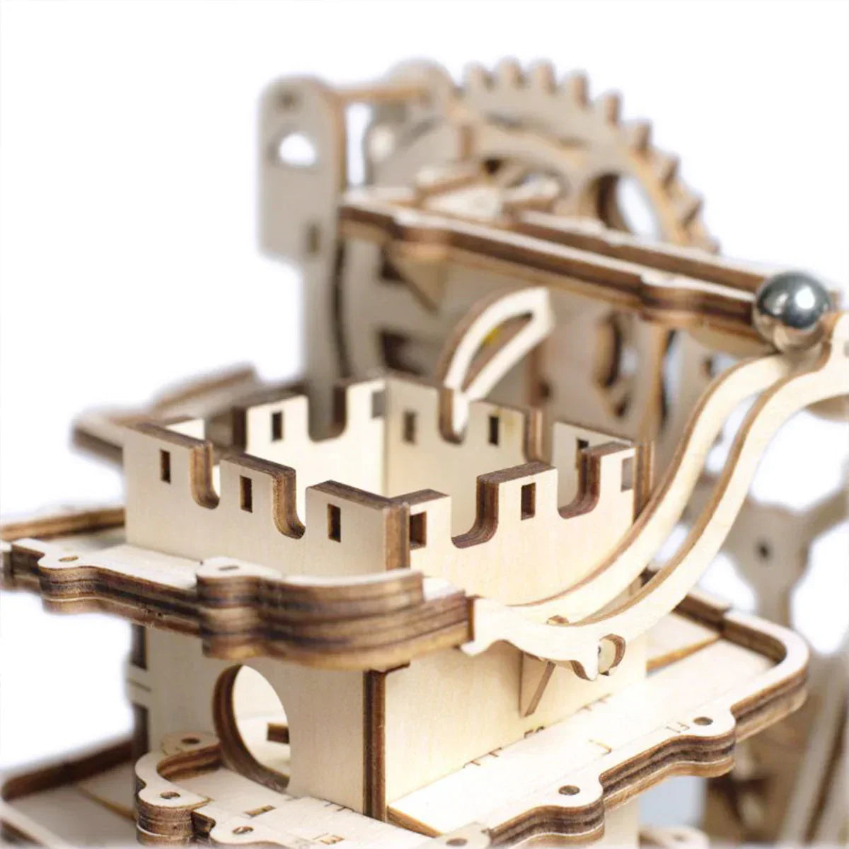 Detailansicht einer mechanischen Murmelbahn aus Holz mit Zahnrädern und einer Metallkugel