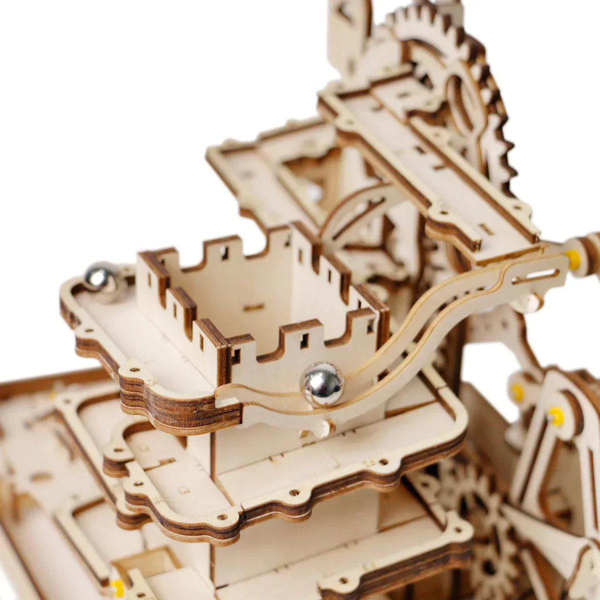 Detailansicht einer mechanischen Kugelbahn aus Holz mit Zahnrädern und einer Metallkugel