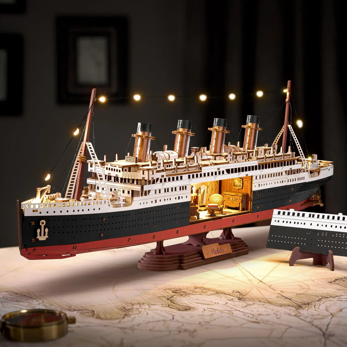 Modell der Titanic mit Lichtern auf einem Tisch mit einer Karte und einem Kompass