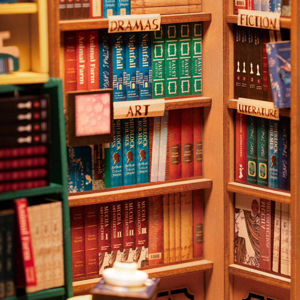 Miniatur Buchregal mit thematisch sortierten Buchreihen und kleinen Schildern