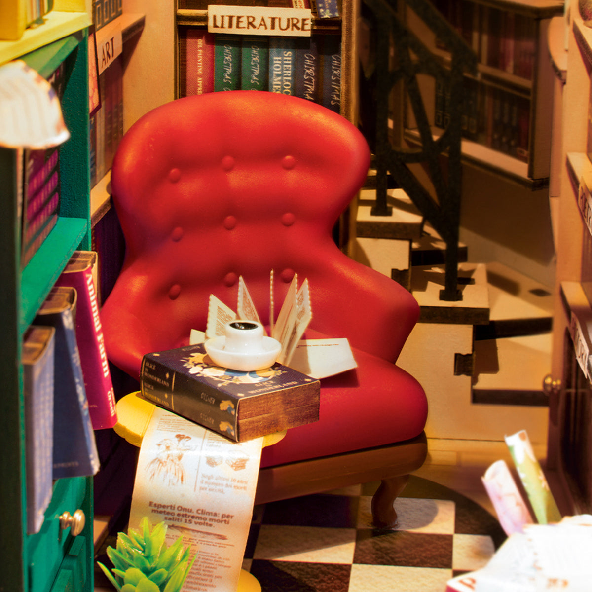 Roter Sessel in einer Miniatur Bibliothek mit Büchern und einer Kaffeetasse