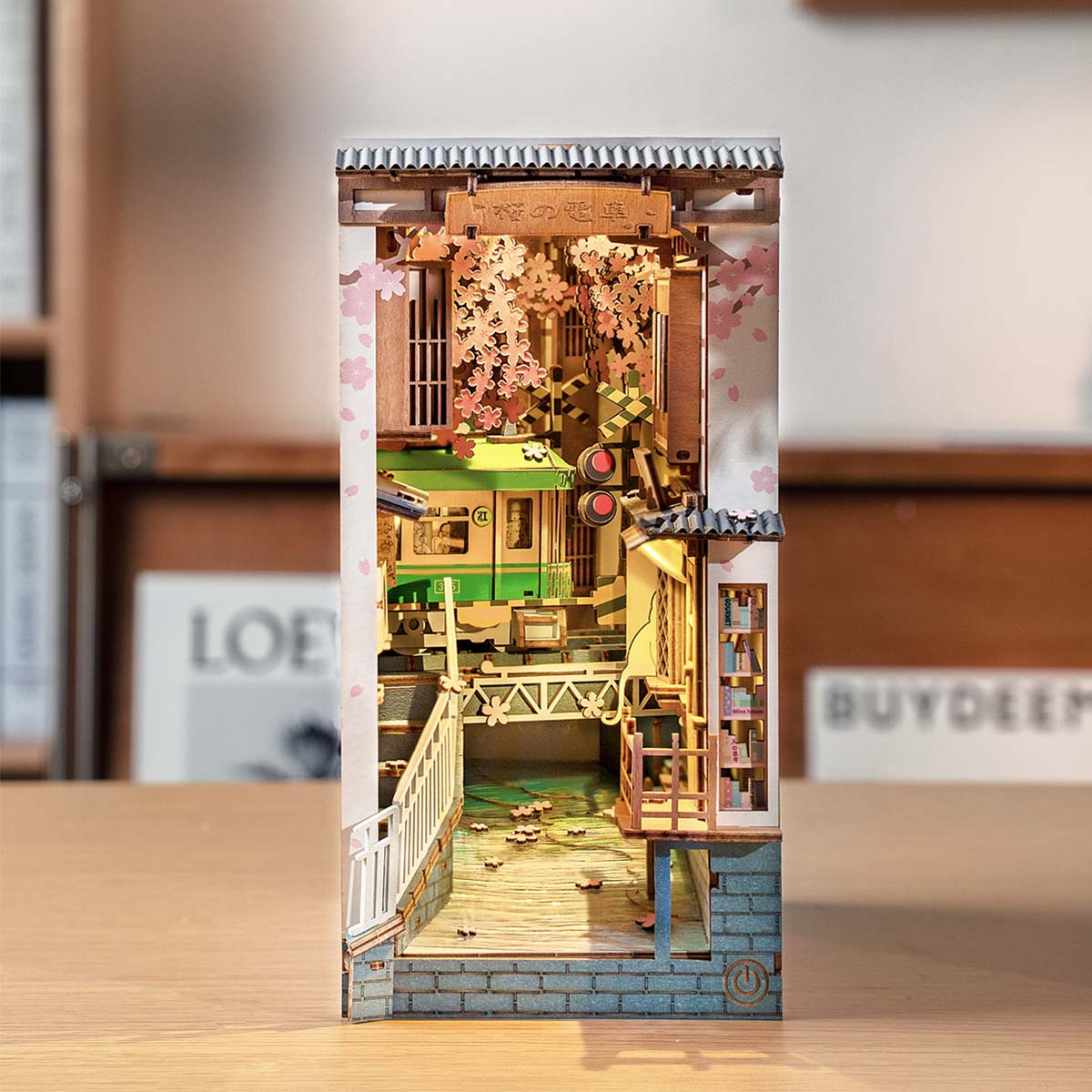Miniaturmodell einer japanischen Straßenszene mit Zug und Kirschblüten
