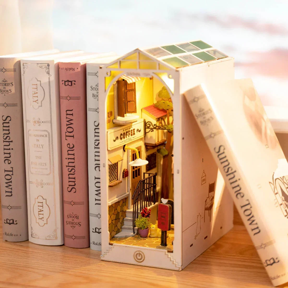 Beleuchtetes Buchstützenmodell mit einer Miniaturkaffeebar zwischen Büchern
