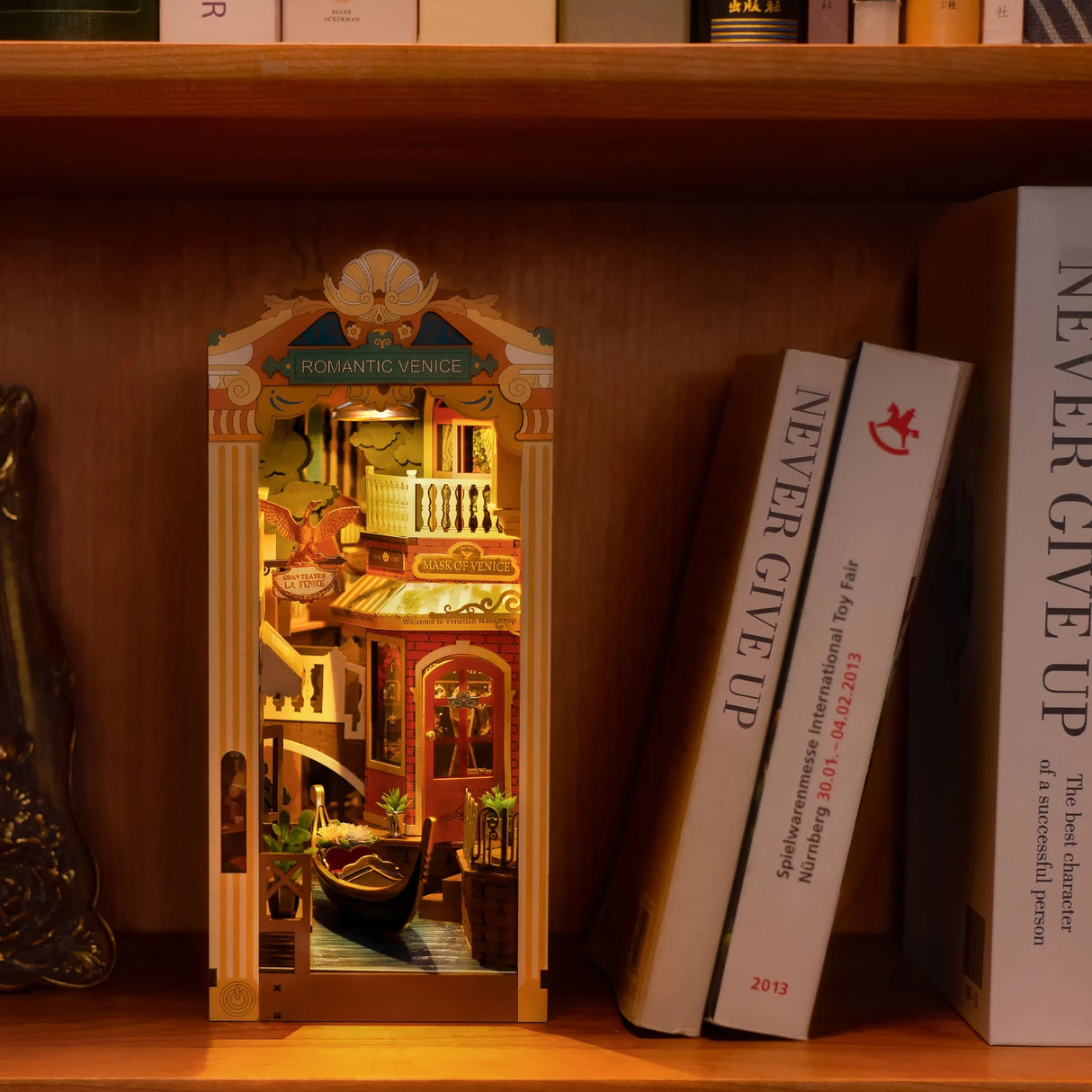 Beleuchtetes Venedig Diorama als Buchstütze zwischen zwei Büchern im Regal