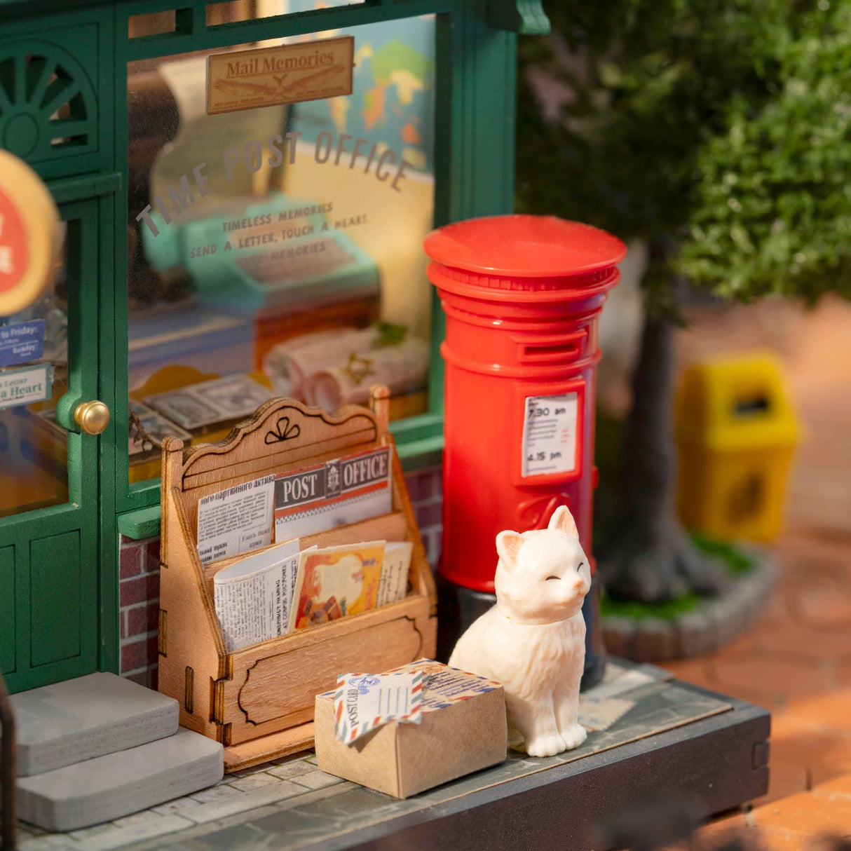 Miniatur Postamt mit rotem Briefkasten und einer Katzenfigur