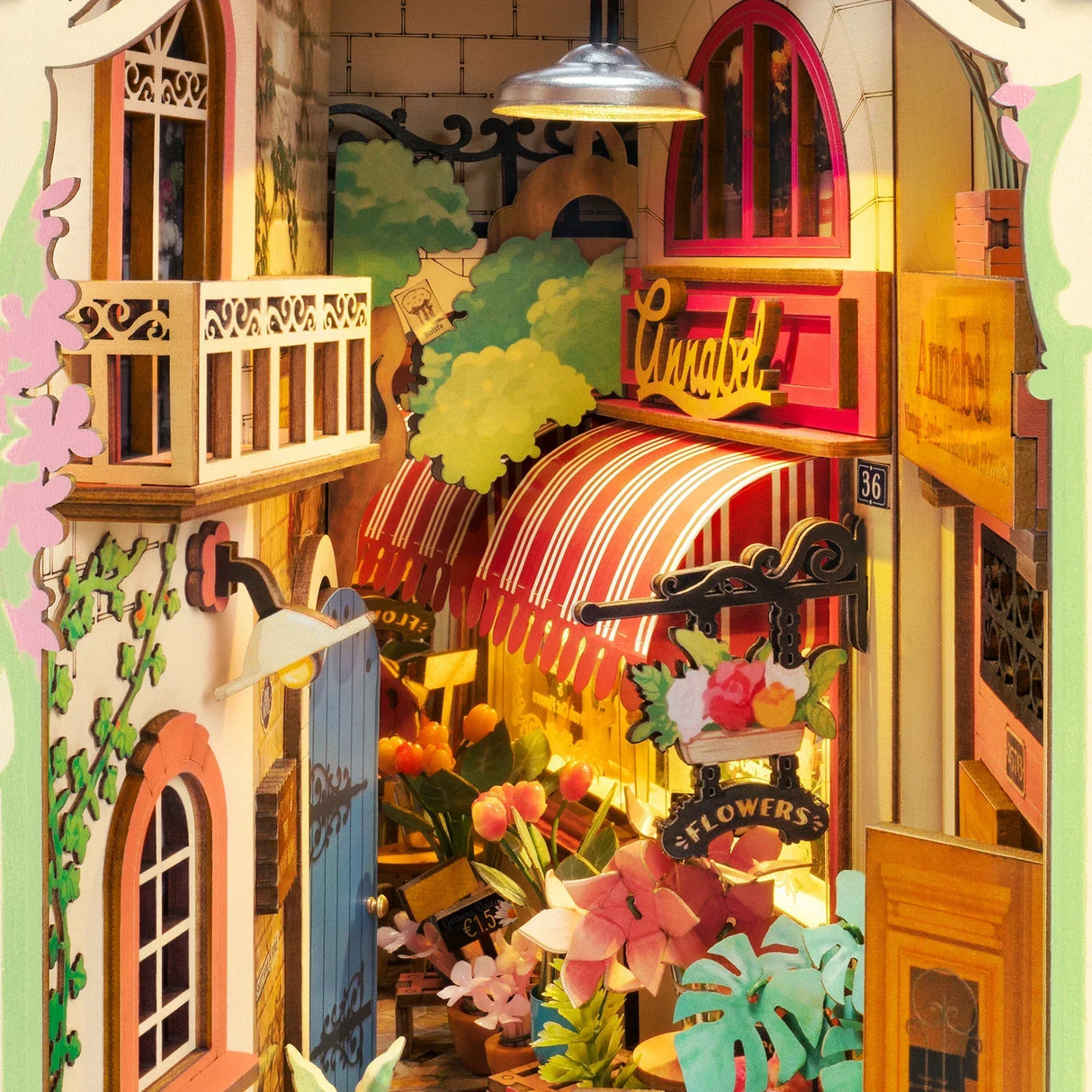 Miniaturmodell eines Blumenladens mit rot-weiß gestreifter Markise und beleuchtetem Innenraum