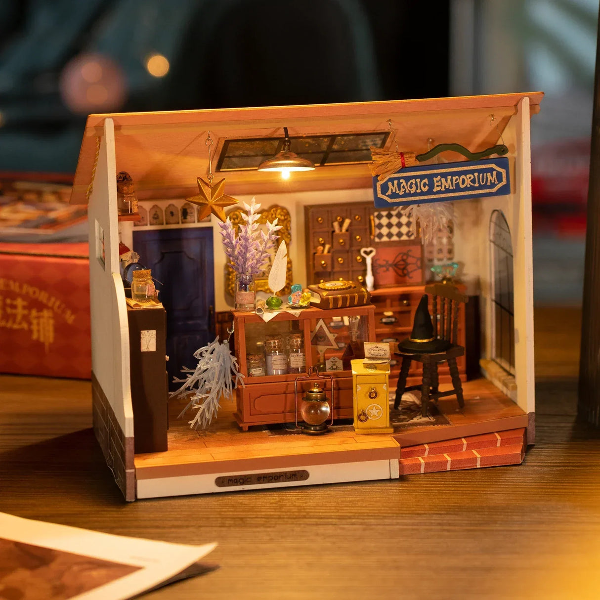 Miniaturmodell eines Zauberladens mit Regalen, Zauberhut und beleuchteter Deckenlampe