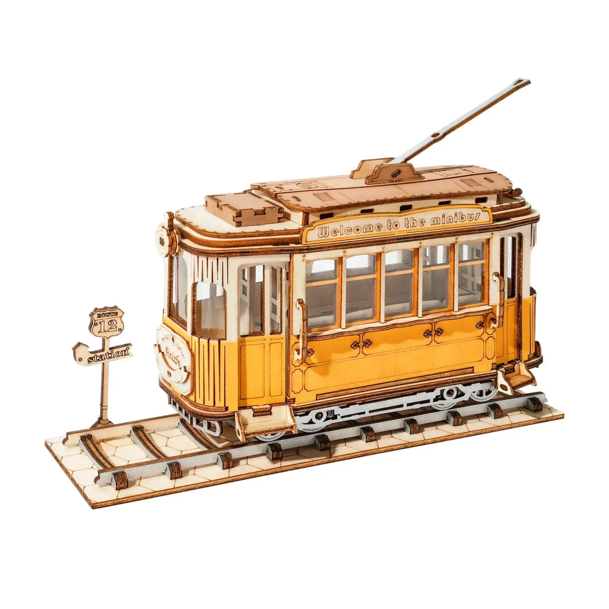 Holzmodell einer gelben Straßenbahn auf Schienen mit Haltestellenschild