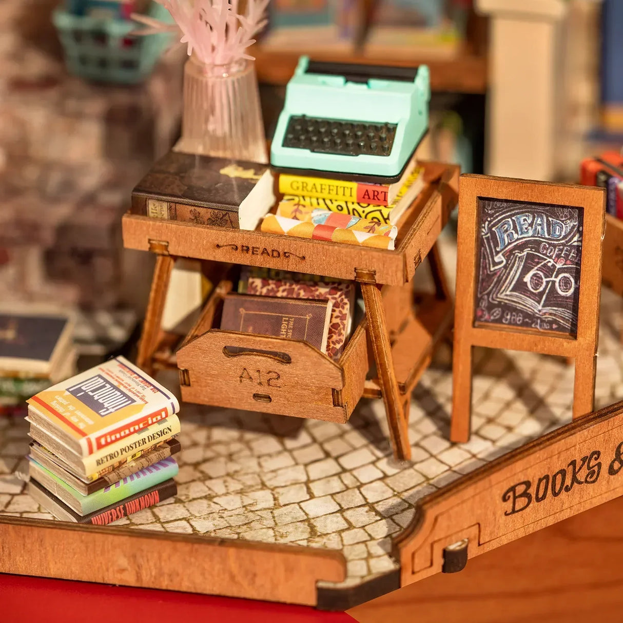 Miniaturmodell eines Holztisches mit Schreibmaschine und Buecherstapel sowie einem kleinen Aufsteller