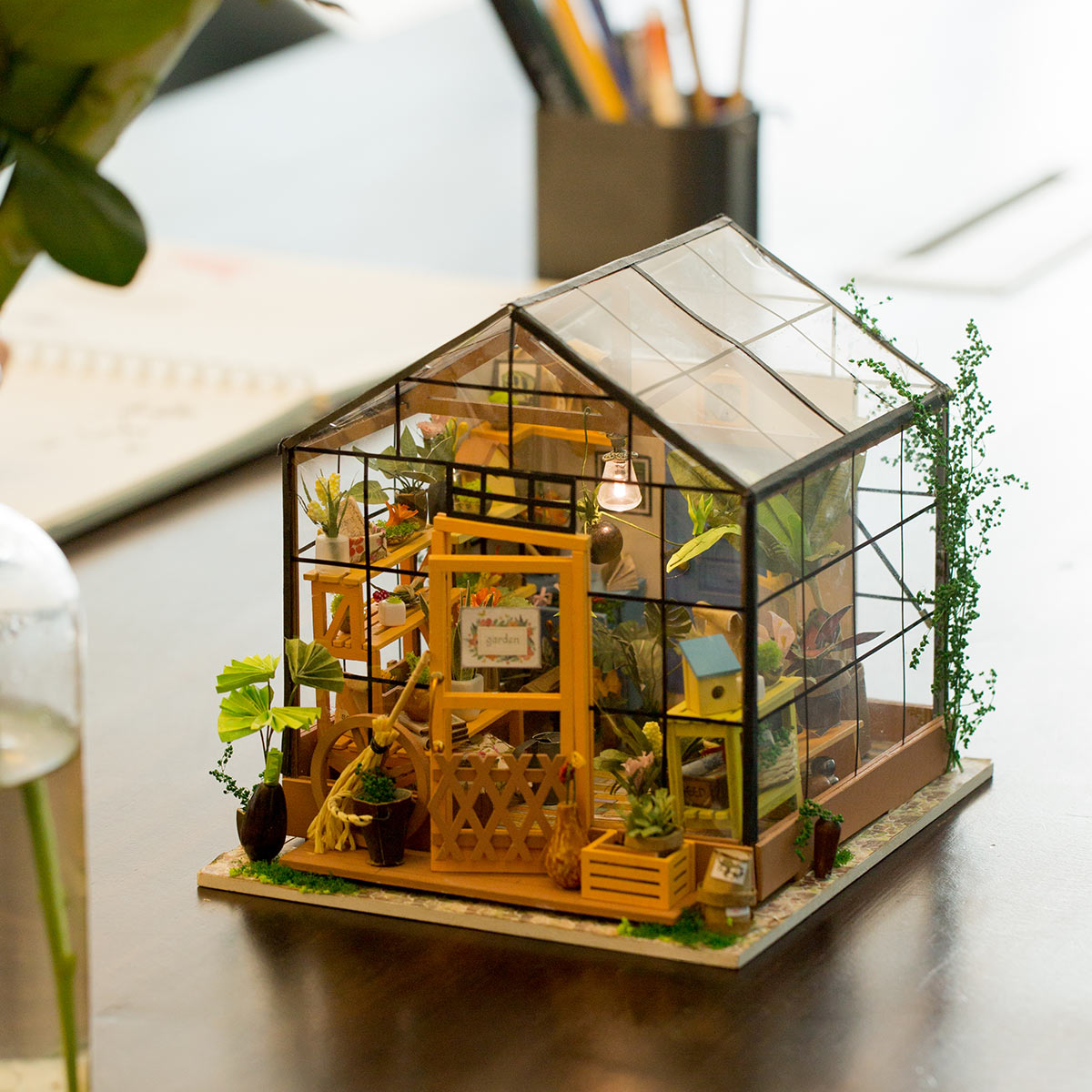 Miniatur Gewächshaus Modellbausatz mit Pflanzen und gelber Tür