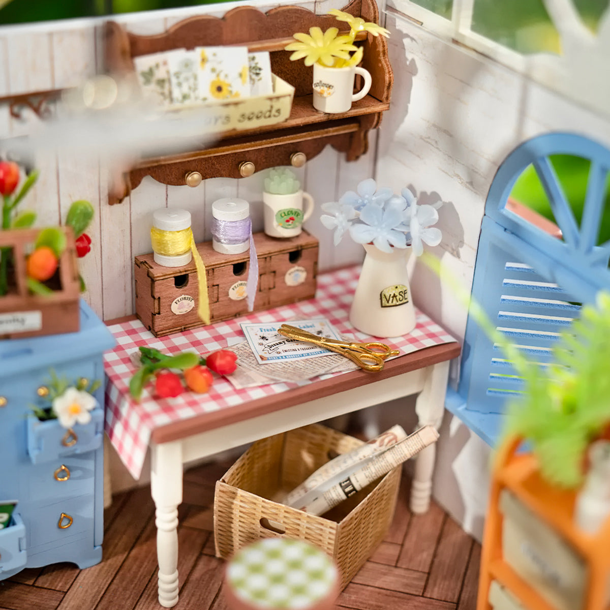 Miniaturwerkstatt mit Tisch karierter Tischdecke Blumenvasen Garnrollen und Bastelschere