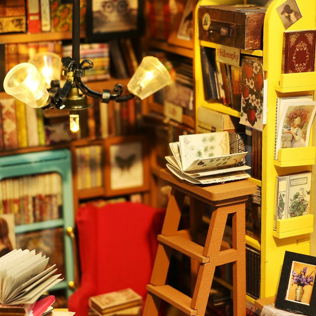 Miniatur Bibliothek mit Leiter Buechern und beleuchtetem Kronleuchter