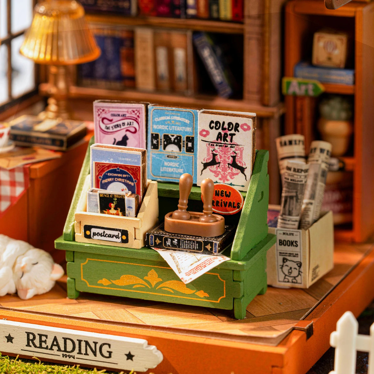 Miniatur Buchregal mit kleinen Büchern Postkarten und Stempeln in einer Bastelkulisse
