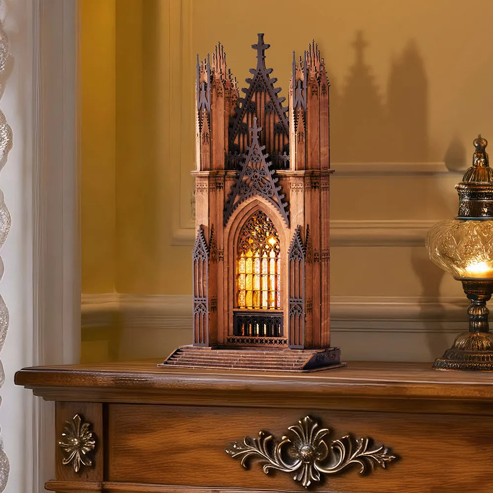 Gotische Kathedrale aus Holz mit beleuchtetem Buntglasfenster auf einem Holztisch