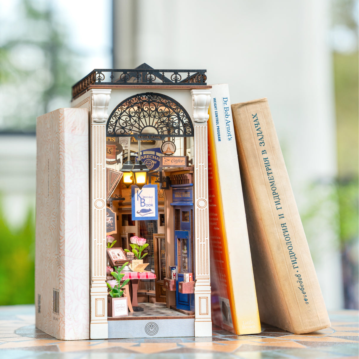 Miniatur-Buchladen-Diorama mit zwei Büchern daneben
