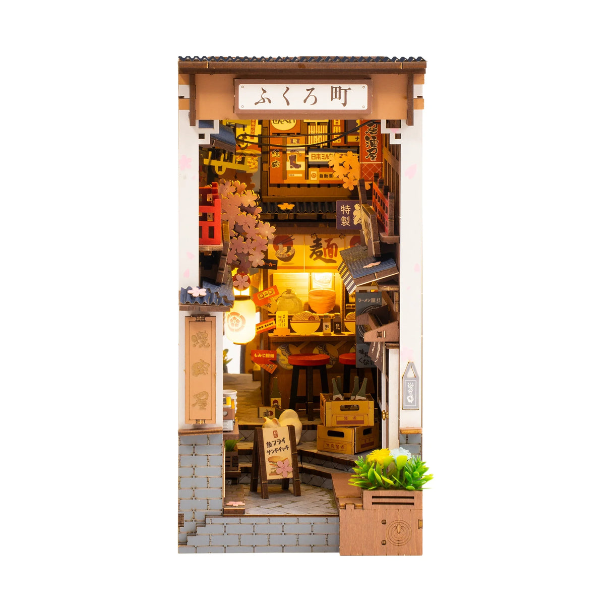 Miniatur-Diorama eines beleuchteten japanischen Ramen-Ladens mit Kirschblüten und Schildern