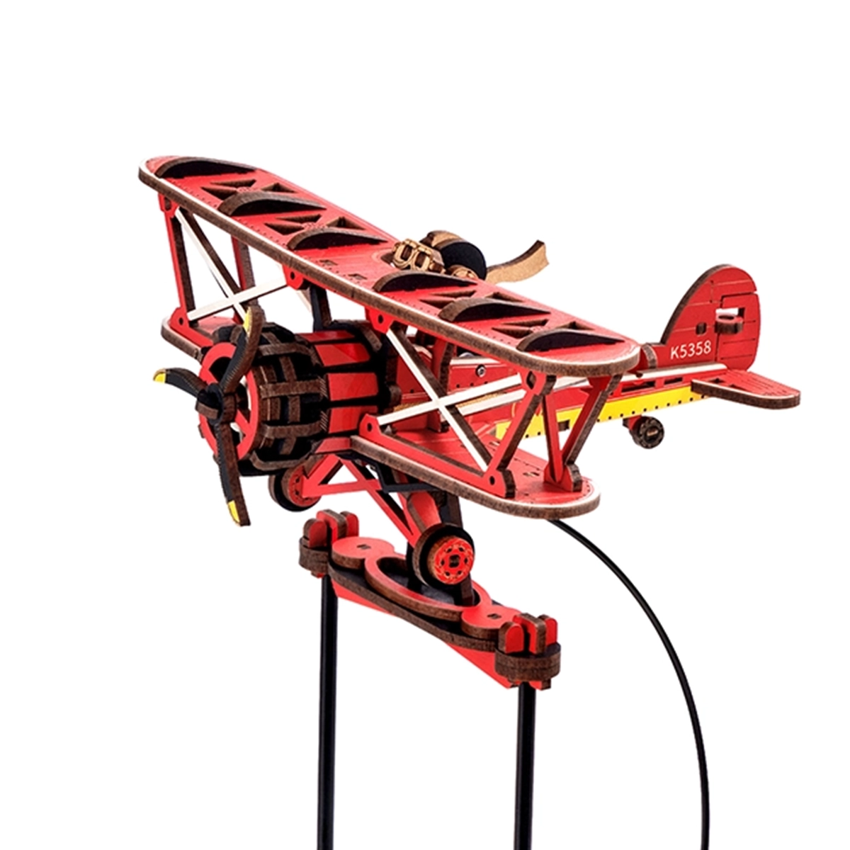 Rotes Holzflugzeugmodell mit Propeller und Fahrwerk auf schwarzem Ständer