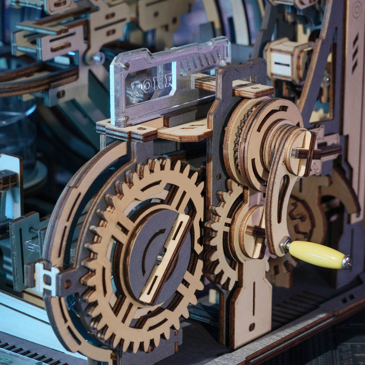 Nahaufnahme eines hölzernen mechanischen Puzzles mit Zahnrädern und einem gelben Griff