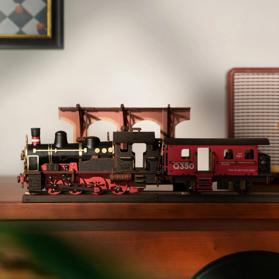 Modell einer schwarzen und roten Dampflokomotive mit einem roten Waggon auf einem Holzregal