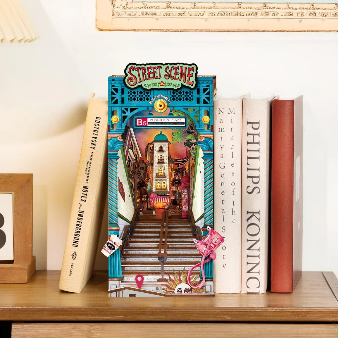 Bücherregal mit einem Buchstützen-Diorama einer beleuchteten Straßenszene mit Treppen und Gebäuden
