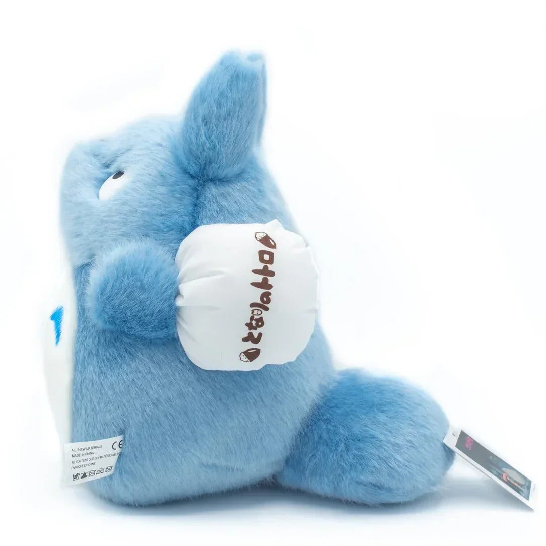 Blaues Plüschtier in Form von Totoro mit weißem Beutel an der Seite