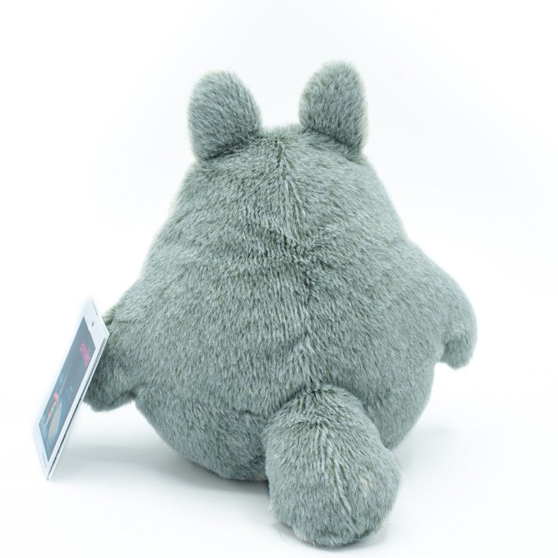 Graues Plueschtier in Totoro Form von hinten gesehen mit einem Produktetikett am Arm