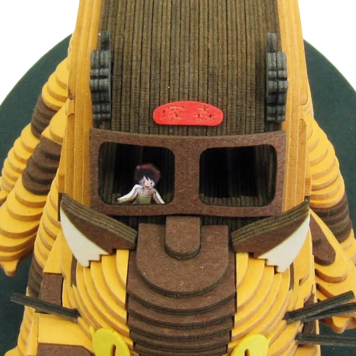 Nahaufnahme eines hölzernen Modells eines Roboters mit einem kleinen Mädchen in einem Fenster
