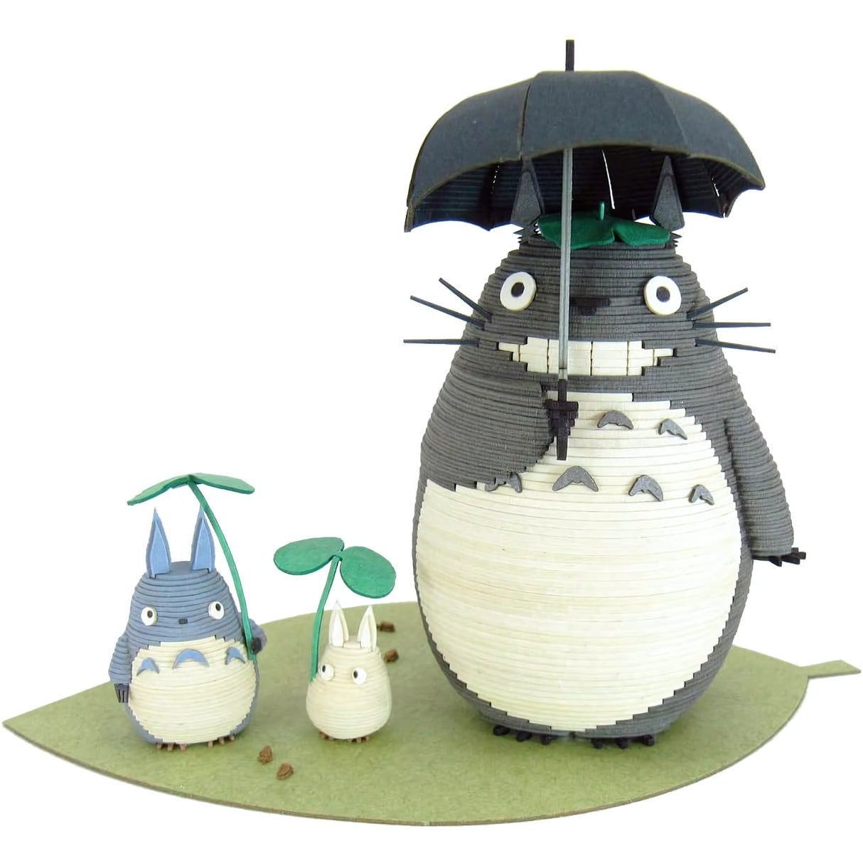 Totoro-Figuren aus Papier auf einem grünen Blatt, großer Totoro mit Regenschirm, kleinerer mit Blatt