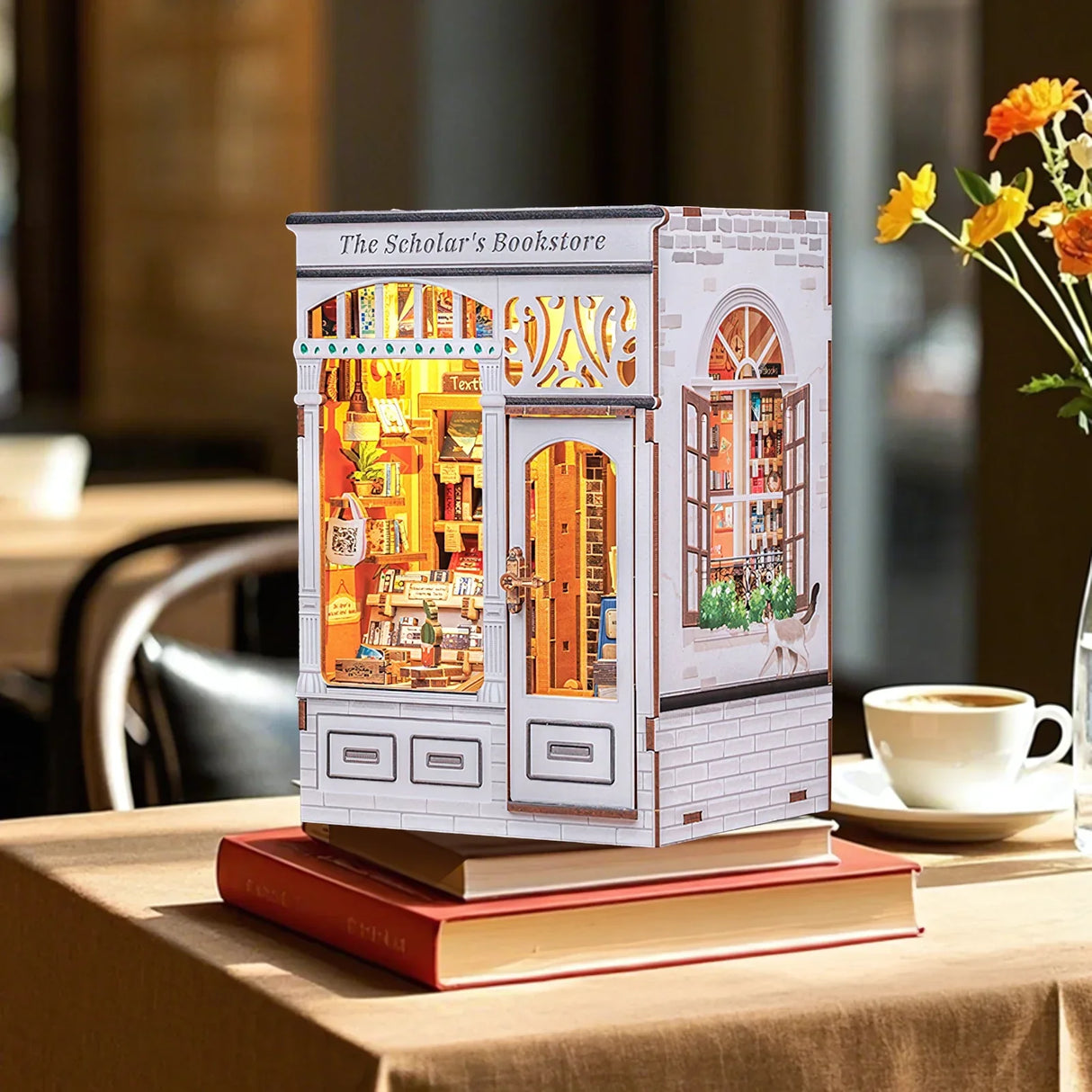 Miniatur-Buchladen-Diorama auf einem Tisch mit Büchern, Kaffee und Blumen