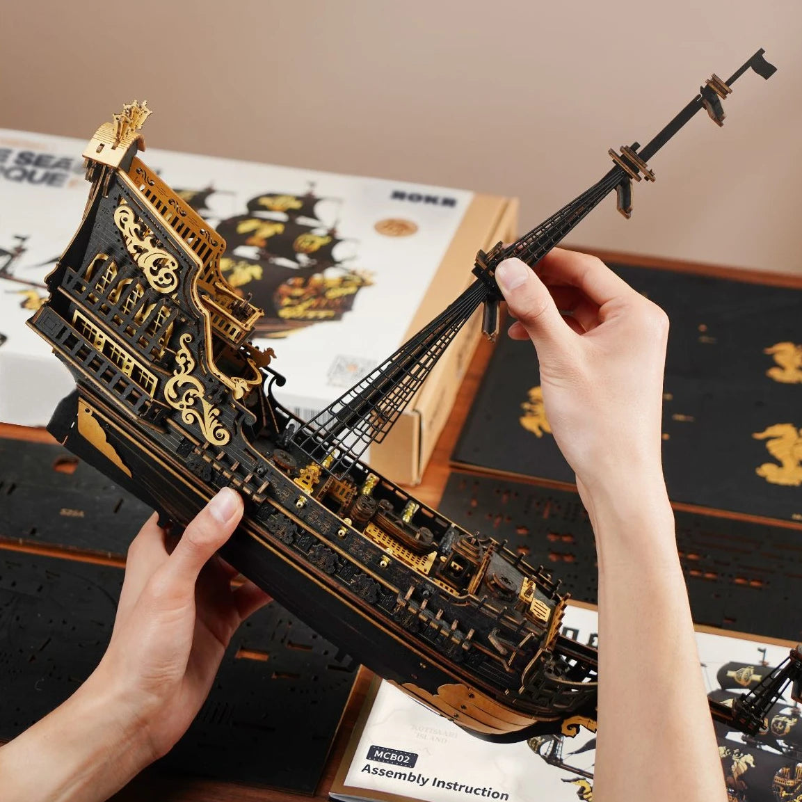 Zusammenbau eines hölzernen Piratenschiffmodells in Schwarz und Gold