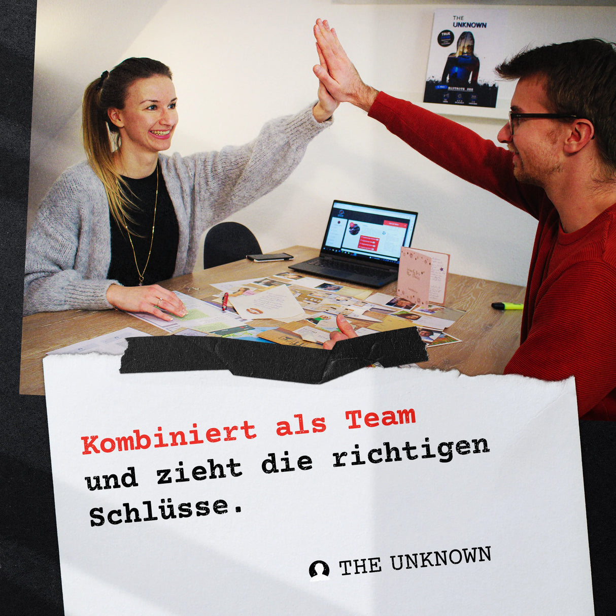 Zwei Personen geben sich High Five ĂŒber einem Tisch mit Laptop und Dokumenten