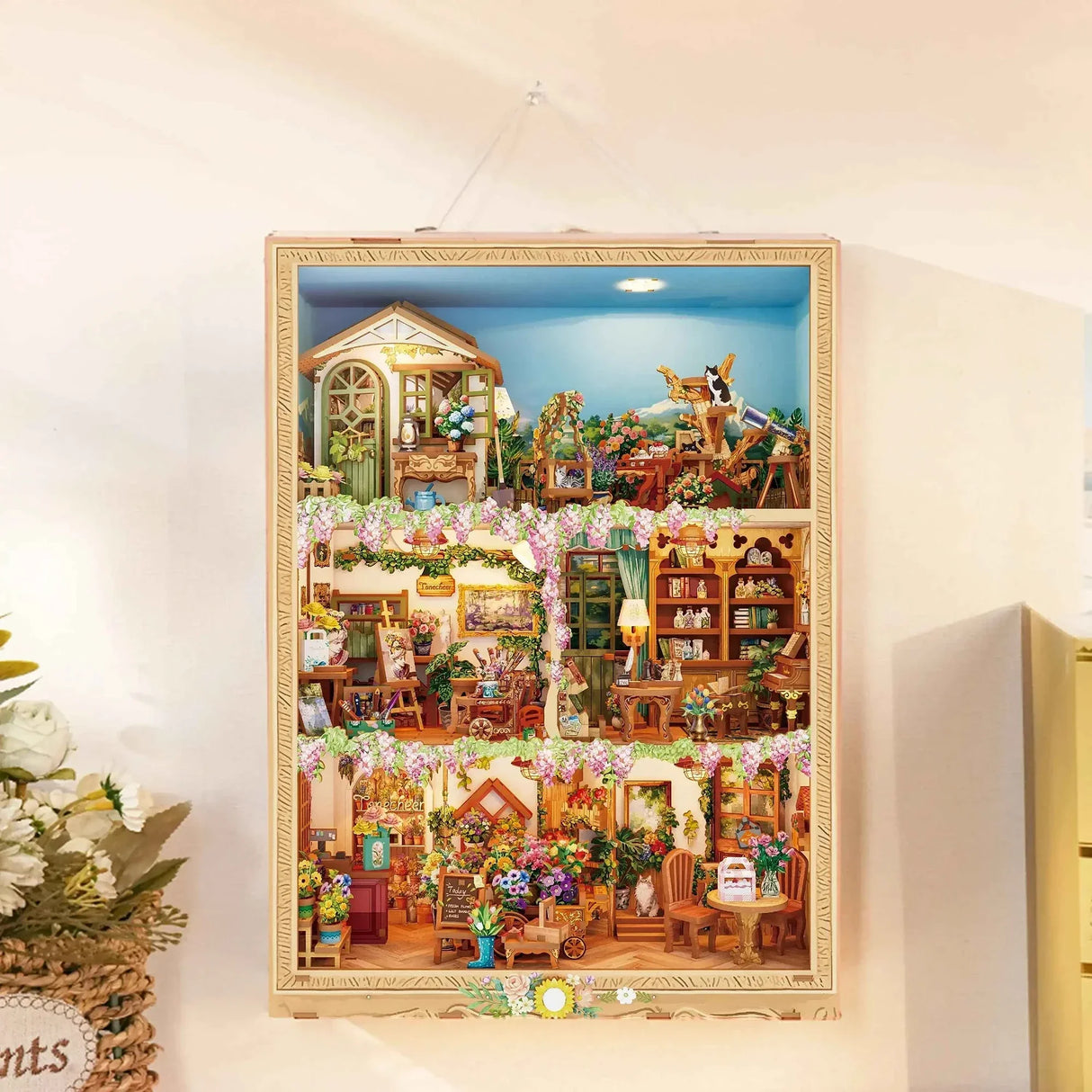 Miniatur-Puppenhaus mit drei Etagen, gefüllt mit Blumen, Möbeln und kleinen Details