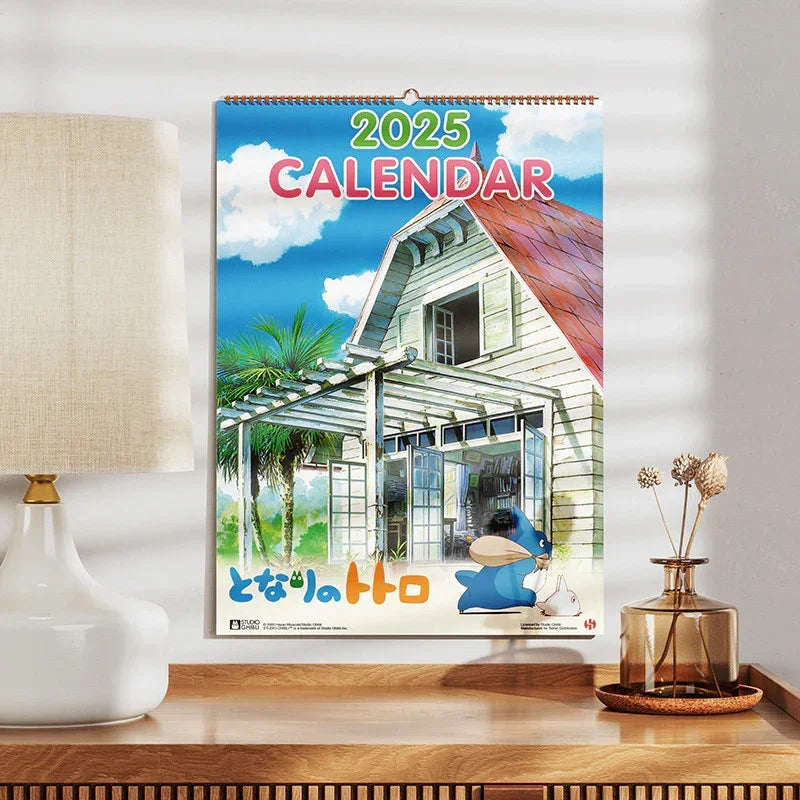 Wandkalender 2025 mit Illustration eines Hauses und Totoro Figuren aus Studio Ghibli