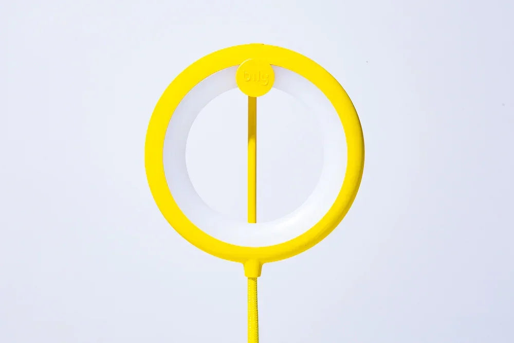 Gelbes Ringlicht mit weissem Diffusor und Kabel vor weissem Hintergrund