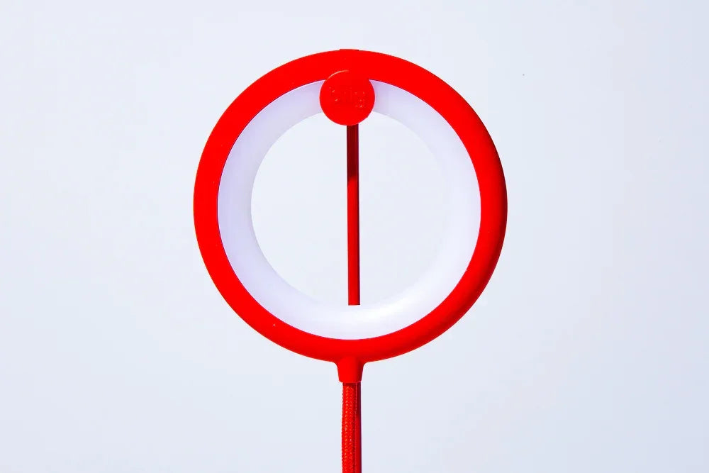 Rotes Ringlicht mit Kabel vor weißem Hintergrund